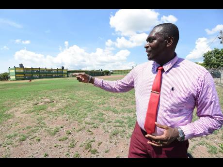 Credit: Ian Allen/Photographer Lynton Weir, principal at Old Harbour High School, points out a section of the 19 acres of land at the St Catherine-located institution.