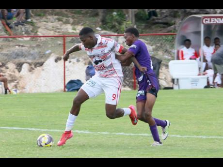 Orane Watson (left) of Glenmuir High powers past Bustamante High’s Omario Brissettt in a daCosta Cup match on September 10.  
Hosts Glenmuir won 13-0 with Watson scoring eight times. 