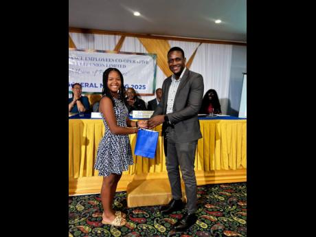 Marissa Bent, daughter of Marsha Smith-Bent, earned a place at Immaculate Conception High School and received her award from Mr. Aldane Milton, IECCU Board Member.