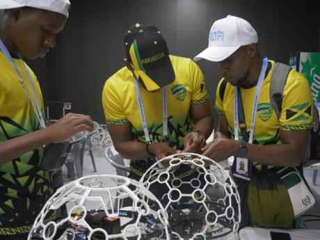 Credit: Contributed Team Jamaica repair their drones between matches at the Drone Soccer World Cup in Jeonju, South Korea, over the weekend.