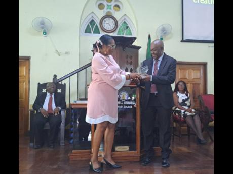 Reverend Dr Davewin Thomas, pastor of the Burchell Circuit of Baptist Churches in St James, receives a presentation from Charmien Christie, deaconess of the Tower Hill Baptist Church within the Burchell circuit. Also pictured are Reverend Carlton Wilson (l