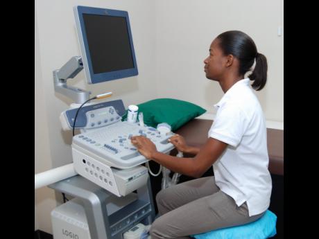 In this September 2013 photo, a technician operates a machine at Elite Diagnostics Limited in Kingston.