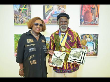 Minister of Culture, Gender, Entertainment and Sport Olivia Grange (left) and Most Outstanding Overall Artist, Nugent Hewitt, 72, who received six gold medals and one silver medal in the 2025 Jamaica Cultural Development Commission Visual Arts Competition.