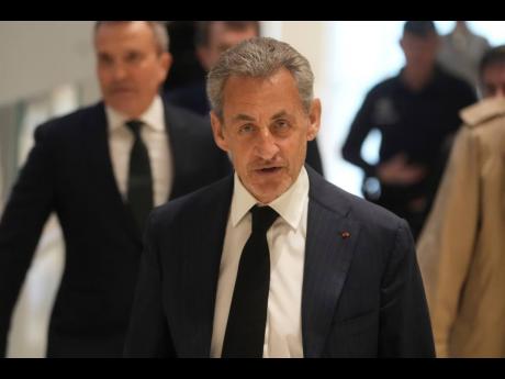 Former French President Nicolas Sarkozy arrives as he goes on trial over alleged illegal financing of his 2007 presidential campaign by the government of late Libyan leader Muammar Gaddafi.