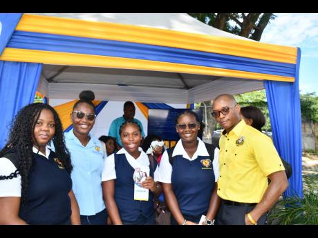 Credit: Contributed Data Protection Officer Desmond Pringle (right) shares in a quick picture with students from Moneague College at the Court Administration Division’s Public Education Day Symposium.