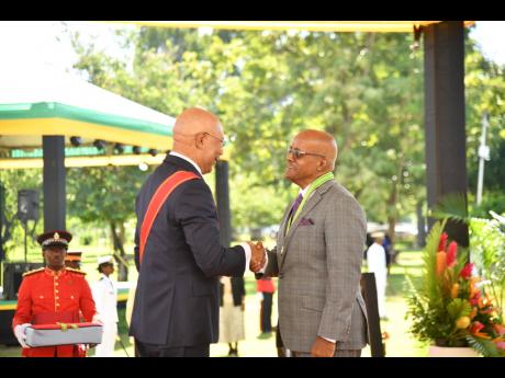 Justice Kissock Laing (right) receiving his membership in the Order of Distinction in the rank of Commander from Governor General Sir Patrick Allen. 