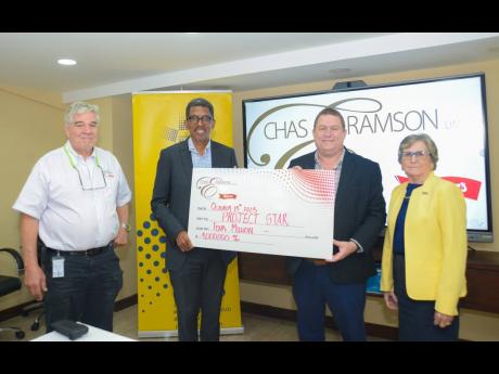Phillip Ramson (second right), managing director of Chas E. Ramson Limited, presents a symbolic cheque valued at $4 million to Project STAR Director, Ian Neita (second left), marking the company’s two-year partnership with Project STAR to support communi
