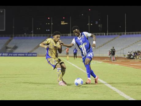 Mount Pleasant winger Daniel Green takes on Defence Force FC’s Christian Bailey during their Concacaf Caribbean Cup first-leg semi-final football game inside the Hasely Crawford Stadium yesterday. Mount Pleasant came out 5-1 winners.