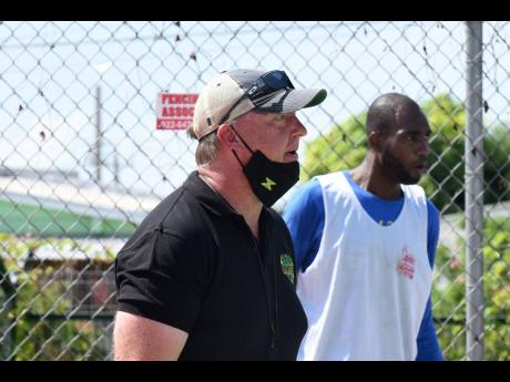 National basketball team head coach Rick Turner (left) gives instructions to members of  the national team during a training session at the Stadium Courts.