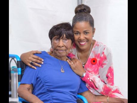 Centenarian Elsa Louise Atkinson is embraced by her daughter Michelle Williams, moments before receiving her Badge of Honour for 60 years of  service in the field of pharmacy.