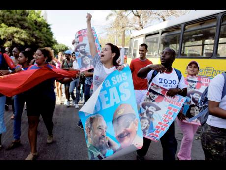 Credit: AP In this 2009 photo students are seen holding posters of Raul Castro and Fidel Castro, and chanting slogans during a march to mark the 48th anniversary of the triumph of Cuban forces during the 1961 Bay of Pigs invasion, in Havana.