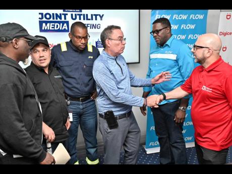 Matthew Samuda (second left), minister of water, environment and climate change; and Daryl Vaz (third right), minister of science, energy, telecommunications and transport; speak with from left Stephen Shaw, communications specialist, at the NWA; Hugh Gran