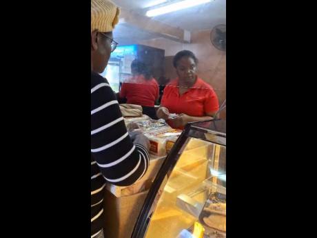 A customer buying baked goods at Top Loaf Bake Shops in Mandeville, Manchester on October 27, 2025, as Hurricane Melissa nears.