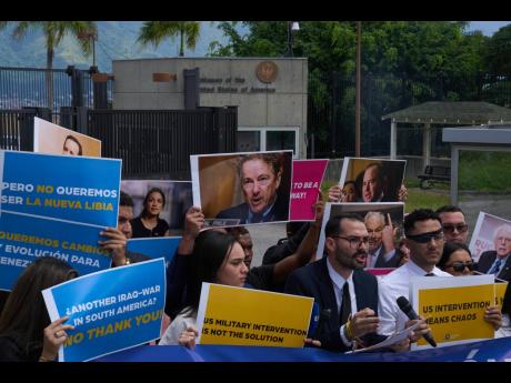 Gabriel Cabrera, president of the Venezuelan Youth Center for Democracy, gives a statement outside of the US embassy with members of the organisation holding signs against US intervention, in reference to US warships operating in the Caribbean, in Caracas,