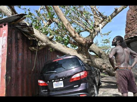 A man looks on at damage caused by Hurricane Melissa in St Ann’s Bay.