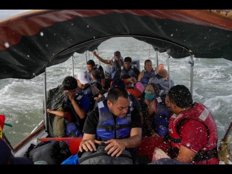 Luis Sanchez (centre) sits with other Venezuelan migrants on a boat leaving Gardi Sugdub on Panama’s Caribbean coast.