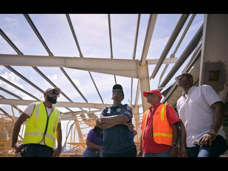 Minister of Local Government and Community Development,  Desmond McKenzie (second left), surveys extensive damage to the Black River Market in St.Elizabeth, following the passage of Category Five Hurricane Melissa on October 28. He is joined by Mayor of Bl