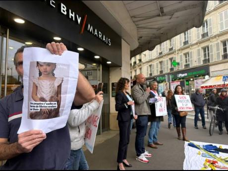 Credit: (AP Photo/Nicholas Garriga) A protester holds a picture of a childlike sex doll outside BHV Marais department store in Parish, Monday, November 3, 2025, where Shein is due to open its first permanent physical store worldwide. (AP Photo/Nicholas Garriga)