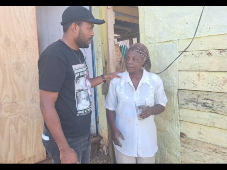 Credit: Ruddy Mathison photo Carl Grant, councillor for the Lluidas Vale Division in St Catherine, seeks to reassure resident Sharon Small, whose one-bedroom house was blown away by Melissa’s outer bands.