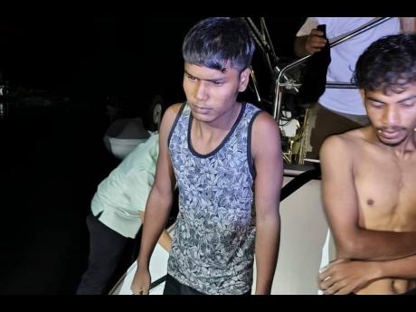 This photo released by Malaysian Maritime Enforcement Agency shows migrants handed over to authorities after they were rescued by a sailboat, in waters off northern resort island of Langkawi.