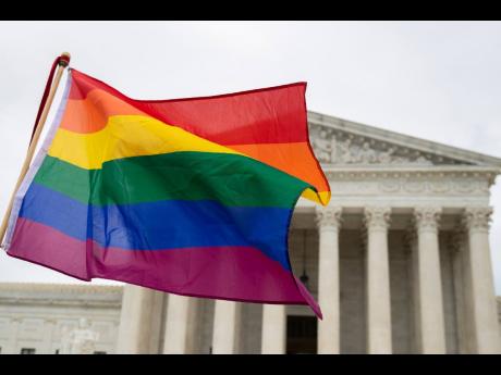 LGBT supporters wave a flag in front of the US Supreme Court, October 8, 2019, in Washington. (AP Photo/Manuel Balce Ceneta, File)