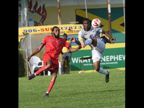 Credit: Ian Allen Cavalier’s Christopher Ainsworth makes an acrobatic attempt at controlling a ball while being closely watched by Spanish Town Police FC’s Raheem Faceey during one of the last Jamaica Premier League games before the competition’s suspension on account