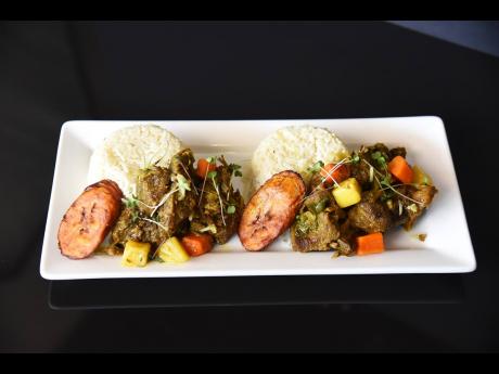 Local favourite, island curry, is paired with coconut-infused white rice and a side of fried plantains. 