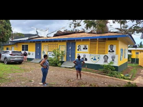 Teachers survey roof damage at Baxter’s Mountain Primary in St Mary.