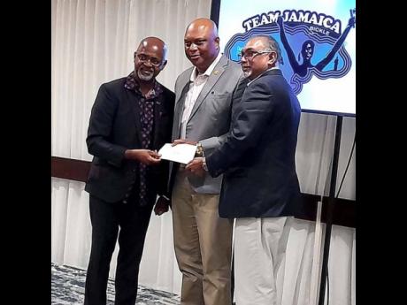 Irwine Clare Sr (left), founder and CEO of Team Jamaica Bickle, presents hurricane relief cheque to GC Foster College of Physical Education and Sport  Principal Maurice  Wilson (centre) and Board Chairman  Vishu Tolan.