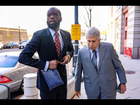 Prakazrel 'Pras' Michel, a member of the 1990s hip-hop group the Fugees, accompanied by defence lawyer David Kenner, right, arrives at federal court April 3, 2023, in Washington. (AP Photo/Andrew Harnik, File)