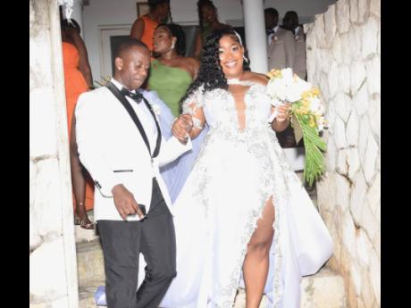 Jevaughn leads his wife, Jordine, down the stairs of their wedding venue.