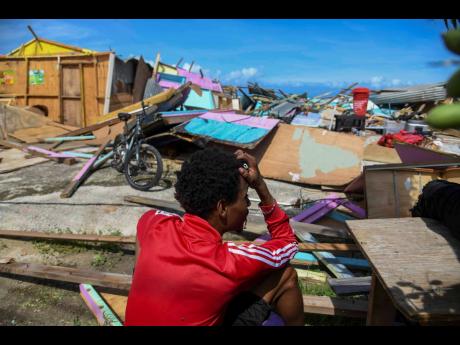 A fisherman in Salem, St Ann, sits among the rubble, holding his head in despair as he surveys damage on the Salem fishing beach during Hurricane Melissa’s passage.