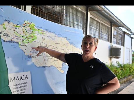 Pastor Mary Wildish gestures toward her colour-coded ‘survival map,’ tracking Operation Blessing’s relief efforts across affected communities in western Jamaica.