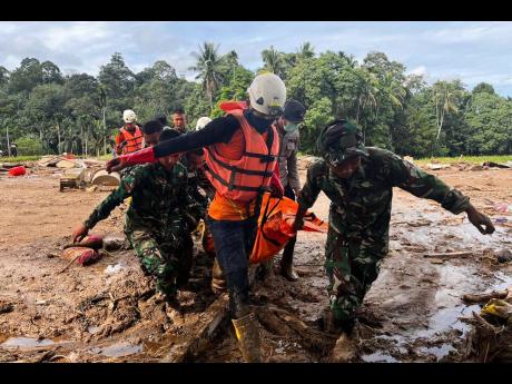Rescuers carry the body of a flood victim in Agam, West Sumatra, Indonesia.