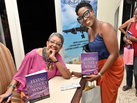 Credit: Rudolph Brown Sandra D. Cooper (left) signed a copy for Annabelle Thomas, who contrasted a navy blue camisole with a warm rust faux-wrap skirt.
