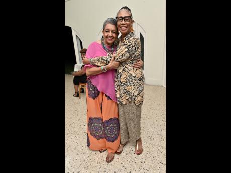 Beverley Manley Duncan (right) pulls Sandra D. Cooper in for a warm, congratulatory squeeze.