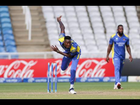 Barbados Pride bowler Dominic Drakes bowls under the watchful eyes of his captain Kyle Mayers during the final of the CGI Super50 against the Trinidad and Tobago Red Force at the Brian Lara Cricket Academy in Couva on Saturday.