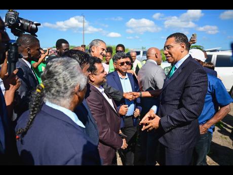 Prime Minister Dr Andrew Holness greets executives of Tropical Sugar Company Limited and other guests during the ground-breaking event on Tuesday.
