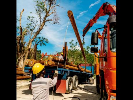 A JPS lineman raises a utility pole as crews work to restore power in St James.