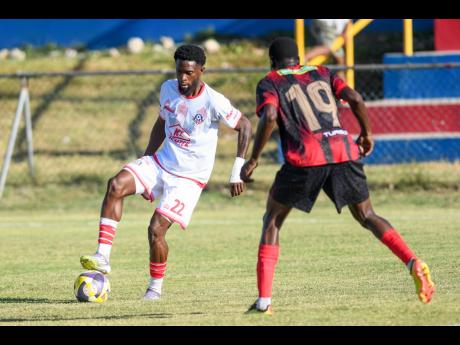 Ronaldo Robinson (left) of Portmore United tries to go around Dexter Manning of Arnett Gardens during their Jamaica Premier League match at Ferdi Neita Park yesterday.