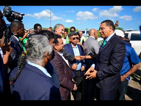 Prime Minister Dr Andrew Holness (right) greets shareholders of the Tropical Sugar Company Limited ahead of the ceremony to break ground for the new sugar factory in Chesterfield, Clarendon, on December 2.
