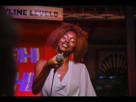 Rising artiste and songwriter Akina Eman points the mic to the crowd to sing along.