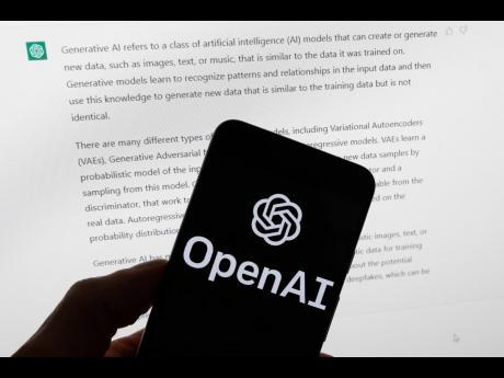 The OpenAI logo is displayed on a mobile phone in front of a computer screen with output from ChatGPT, March 21, 2023, in Boston. (AP Photo/Michael Dwyer, File)