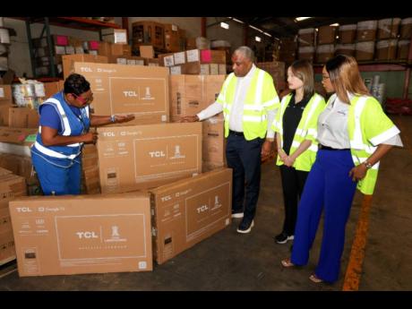 TCL executives check television sets earmarked for distribution to communities affected by Hurricane Melissa in western Jamaica.