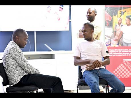 Participants take part in a practice session as programme facilitator Travis Graham (background) observes and guides the exercise.