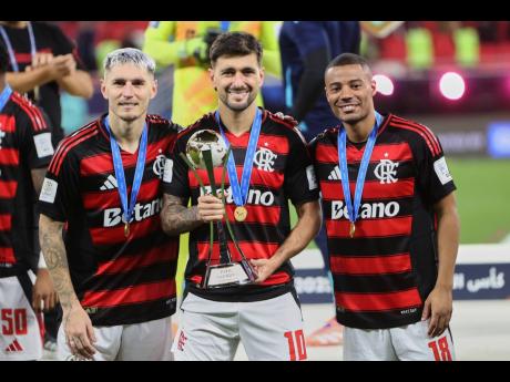 Credit: AP Flamengo's Giorgian de Arrascaeta (centre), Nicolas de la Cruz (right), and Flamengo's Ayrton Lucas pose for a photograph with the trophy after winning the FIFA Intercontinental Cup football match against Pyramids in Doha, Qatar on Saturday.