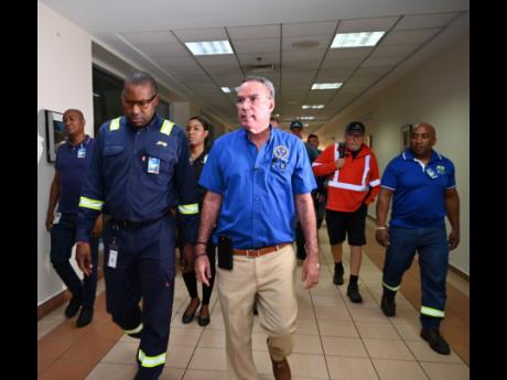 Hugh Grant (left), CEO of the Jamaica Public Service, and Energy Minister Daryl Vaz in discussion during the arrival of 117 linesmen from Canada at the Sangster International Airport in Montego Bay, St James, on Wednesday.