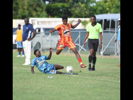 Cornwall College’s Shakeem Gibson hurdles a tackle by McGrath High’s Kepling McFarlane (left) during their ISSA Ben Francis KO semi-final at Drax Hall Sports Complex  yesterday. Cornwall won 2-0.