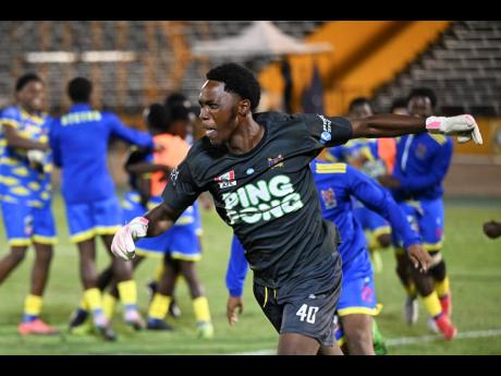 St Elizabeth Technical High School goalkeeper Jahnoi Steadman celebrates saving the penalty that gave his team an 8-7 sudden death penalty shootout win over Glenmuir High School in the ISSA daCosta Cup final at the National Stadium last night.