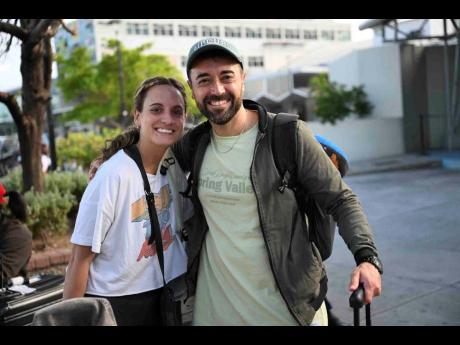 Credit: Ricardo Makyn/Chief Photo Editor First-time visitors Florencia Dellanno and Juan Del Roo, software professionals from Argentina, are looking forward to enjoying jerked chicken and relaxing for the holidays.